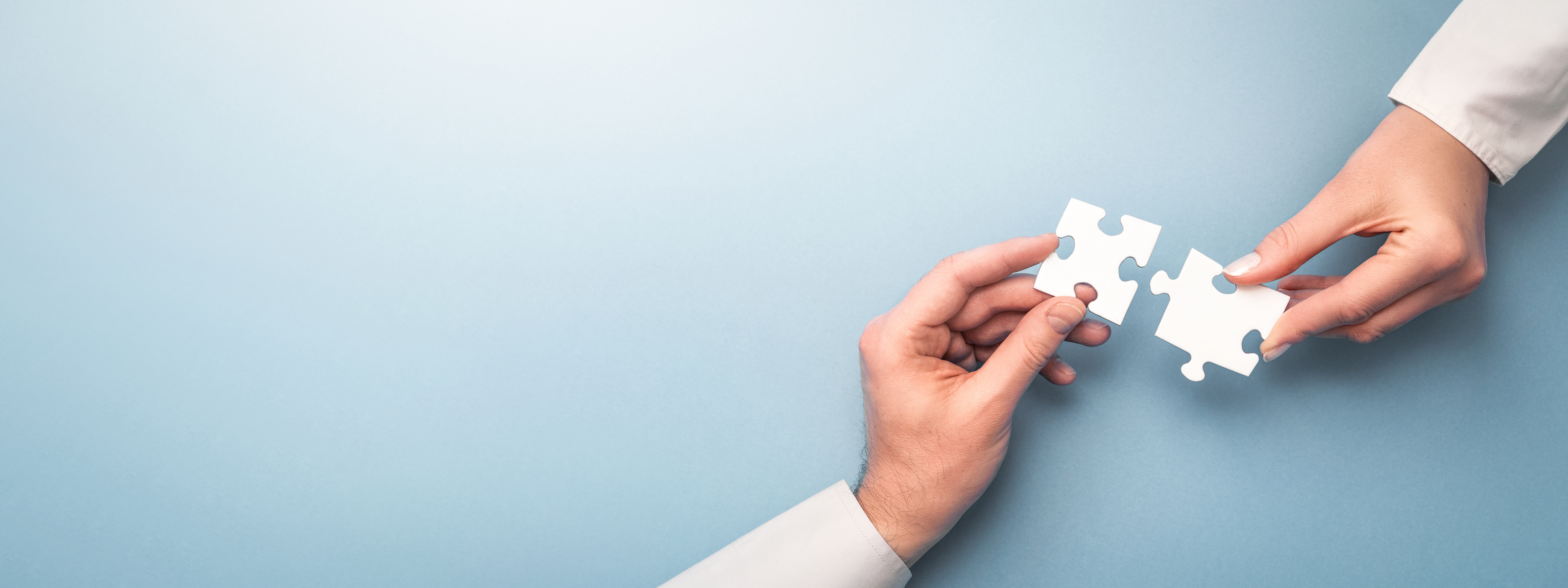 Hands connecting puzzle pieces - Team collaboration